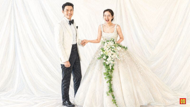 結婚式でタキシードを着て妻のソン・イェジンと笑顔で手を繋ぐヒョンビン